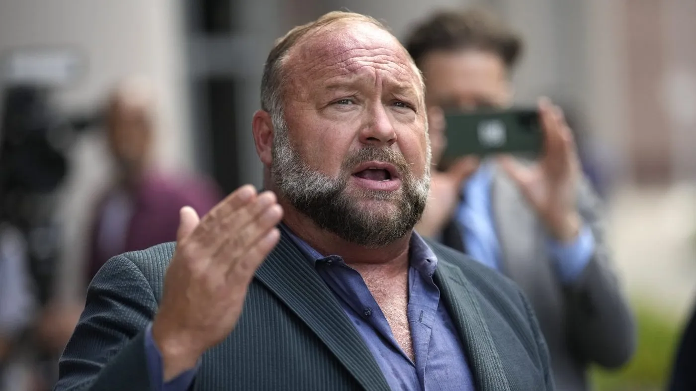 Right-wing conspiracy theorist Alex Jones speaks to the media after arriving at the federal courthouse for a hearing in front of a bankruptcy judge, June 14, 2024, in Houston.