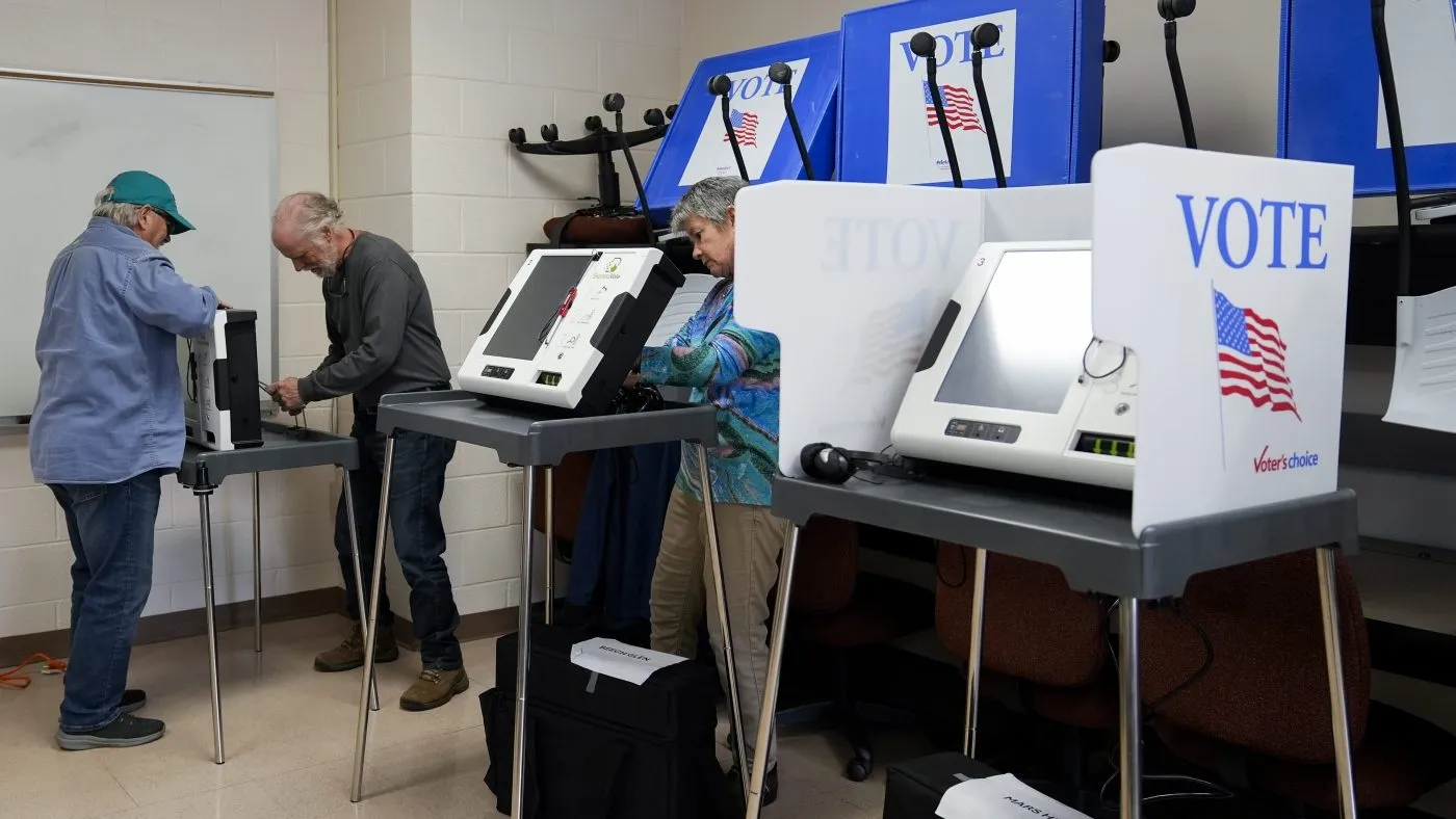 Poll workers set up ballot-marking machines at an early in-person voting site at Asheville-Buncombe Technical Community College, Wednesday, Oct. 16, 2024, in Marshall, N.C. (AP Photo/Stephanie Scarbrough)