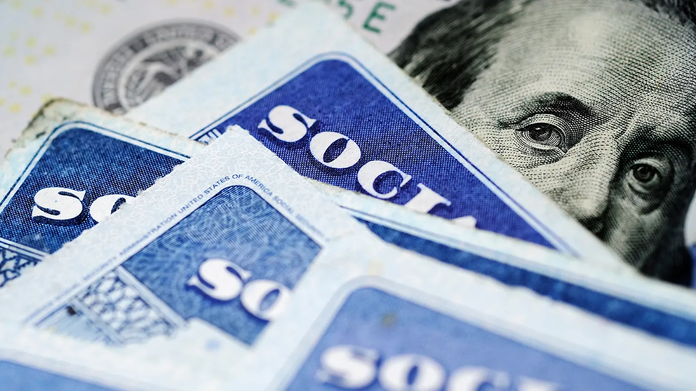 Social Security cards are seen on a $100 bill.
