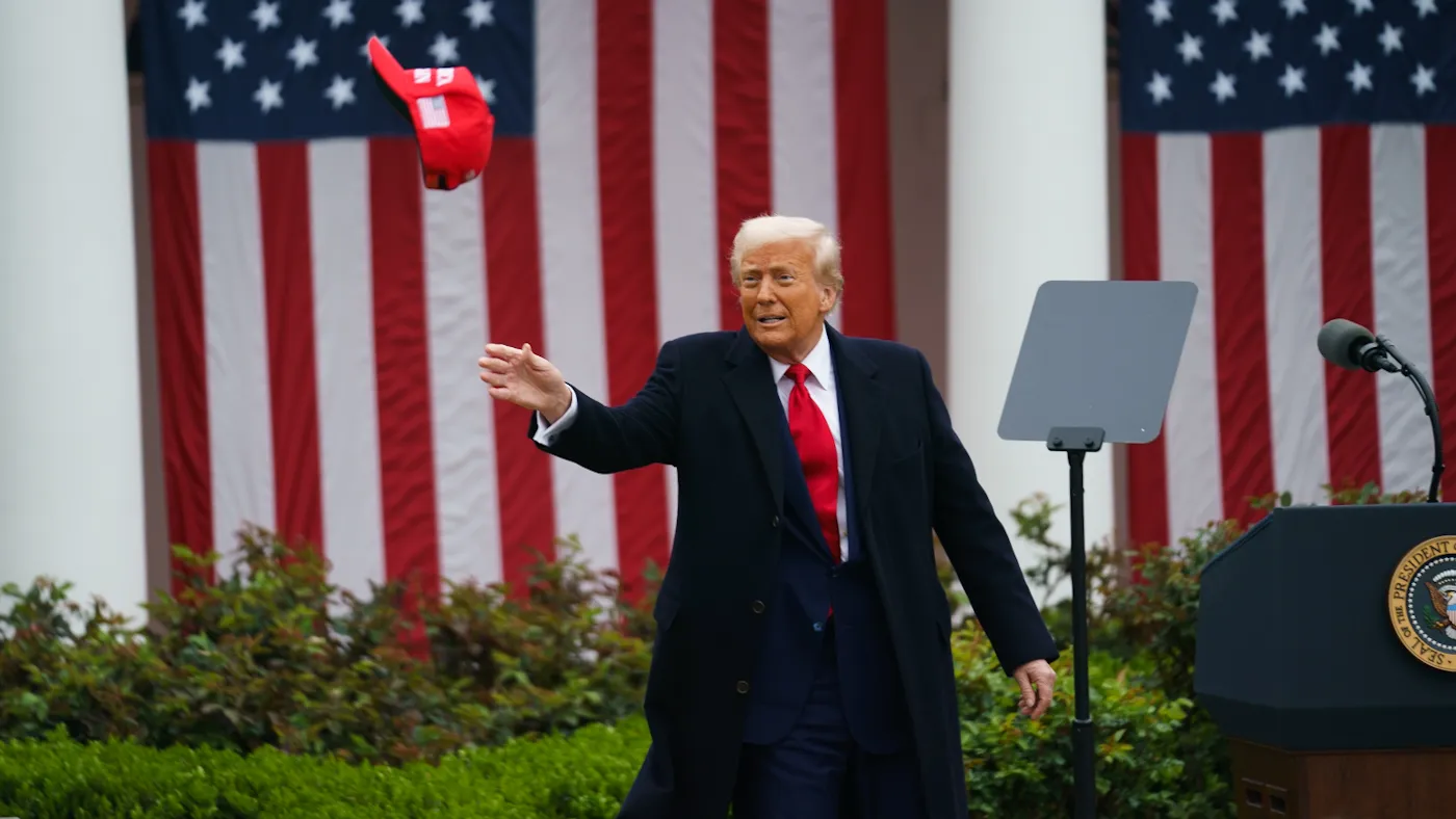 President Trump throws MAGA hats to attendees at the Rose Garden event announcing new tariffs on April 2, 2025.