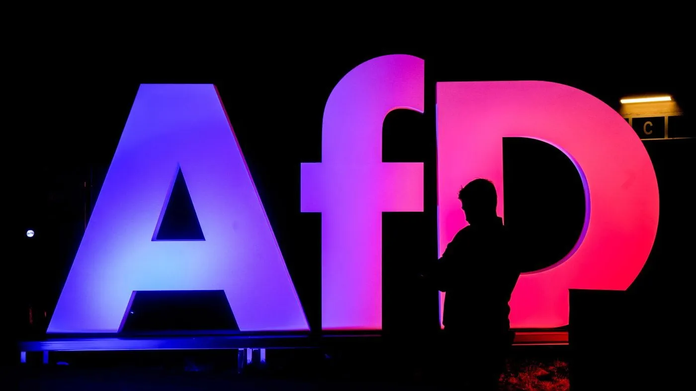 A man stands in front of the logo at the AfD party headquarters in Berlin, Germany, Feb. 23, 2025, after the German national election.