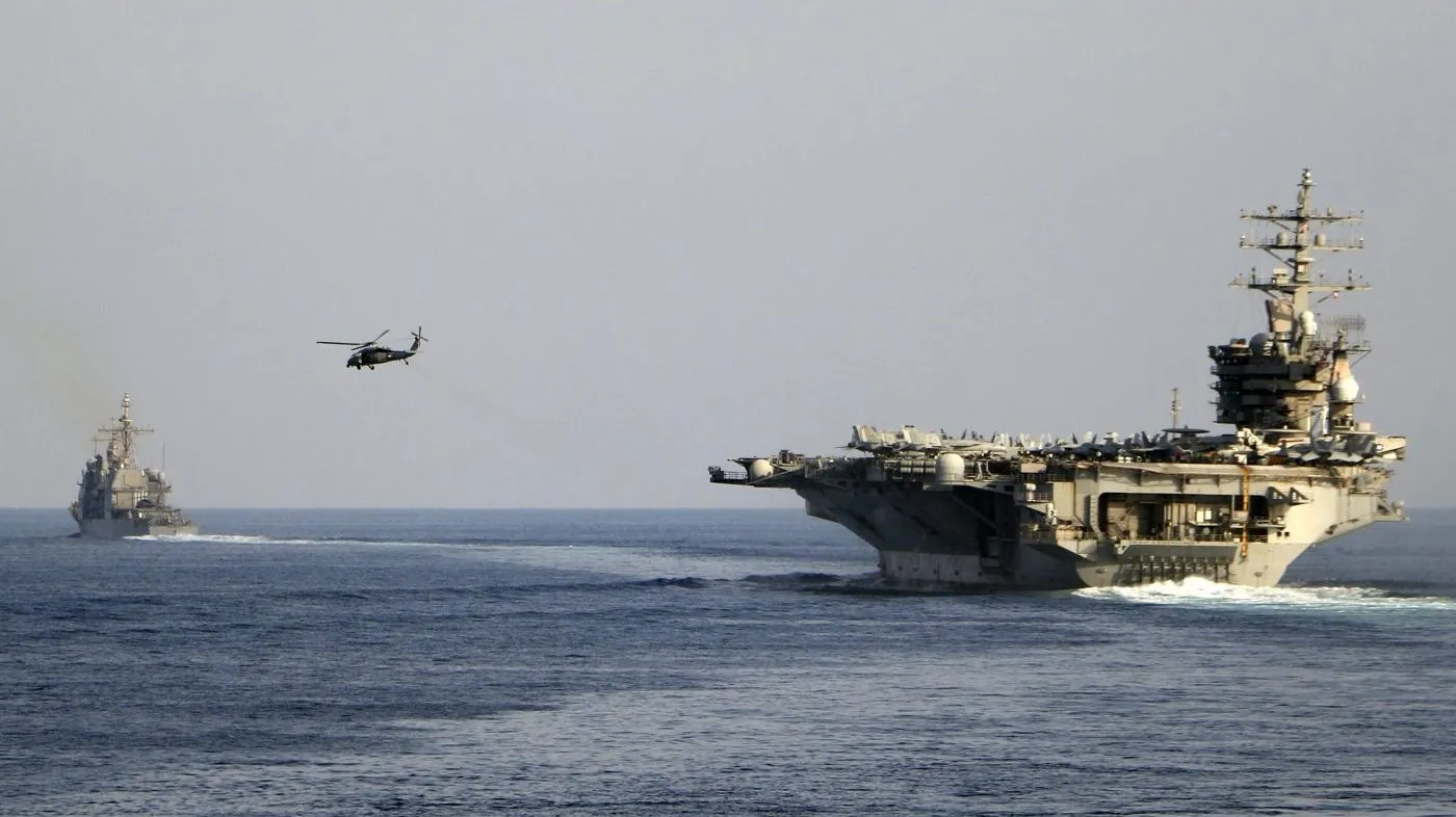 The aircraft carrier USS Dwight D. Eisenhower and other warships cross the Strait of Hormuz into the Persian Gulf on Nov. 26, 2023.