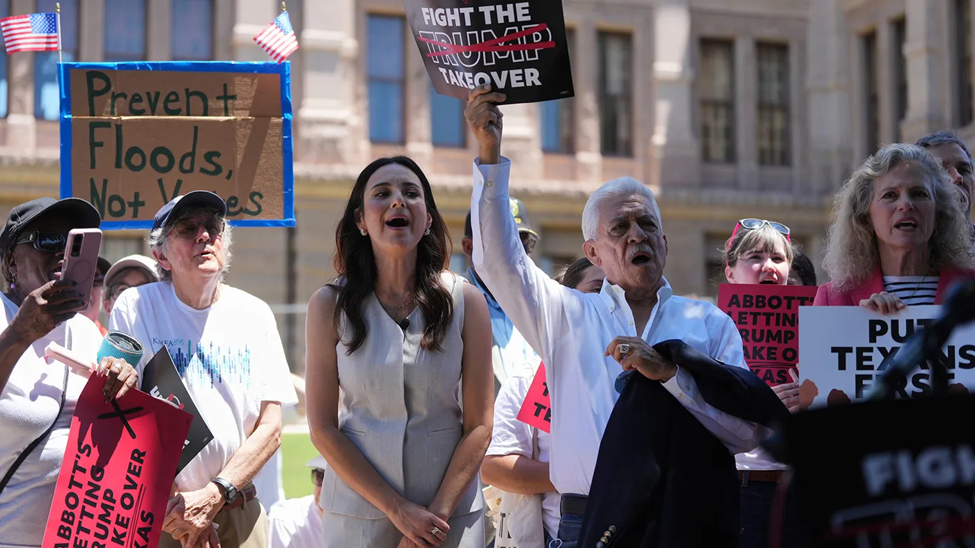 Texas state Rep Gina Hinojosa, center, joins others at a rally to protest against redistricting hearings at the Texas Capitol, July 24, 2025, in Austin, Texas.