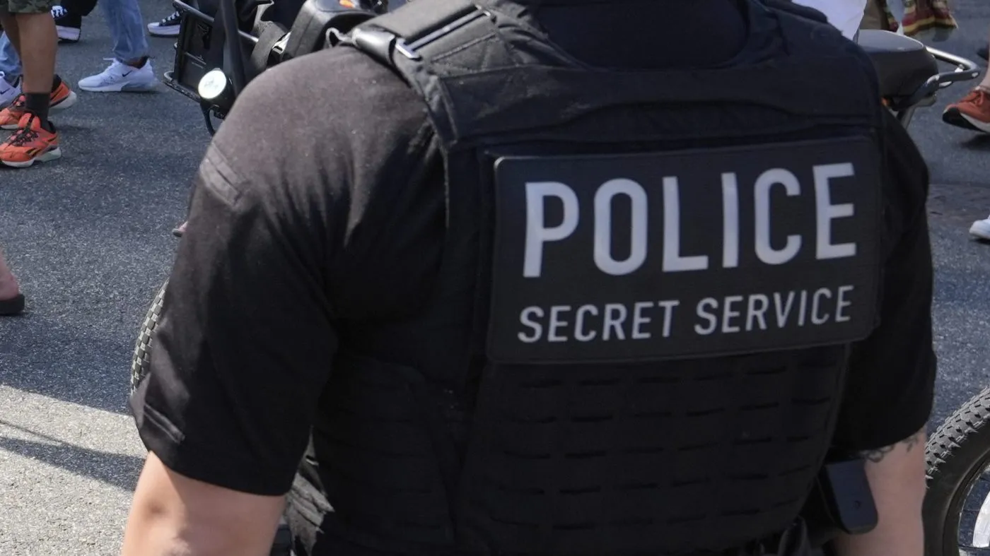 Secret Service police officers watch as activists carrying signs march to the White House to protest President Trump’s federal takeover of policing of the District of Columbia, Aug. 16, 2025, in Washington.