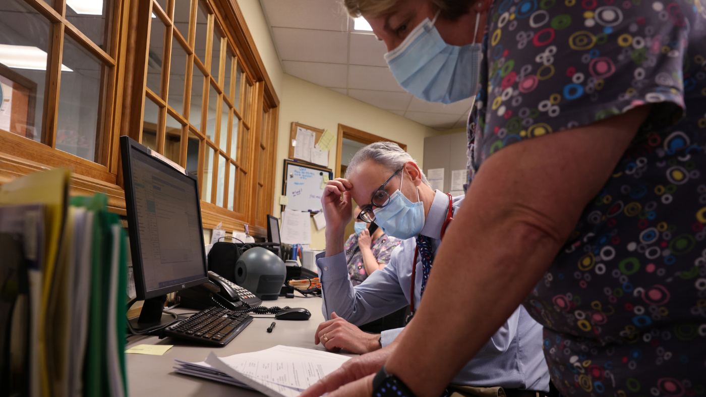 Pediatrician Dr. Aaron Bornstein, left, talks with registered medical assistant Tamara Rivera about a patients medication and billing at Middleboro Pediatrics. (Photo by Craig F. Walker/The Boston Globe via Getty Images)