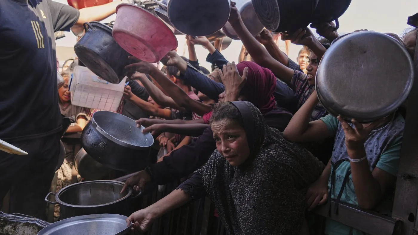 FILE – Palestinians struggle to get donated food at a community kitchen in Khan Younis, southern Gaza Strip, Friday, Sept. 19, 2025. (AP Photo/Jehad Alshrafi, File)