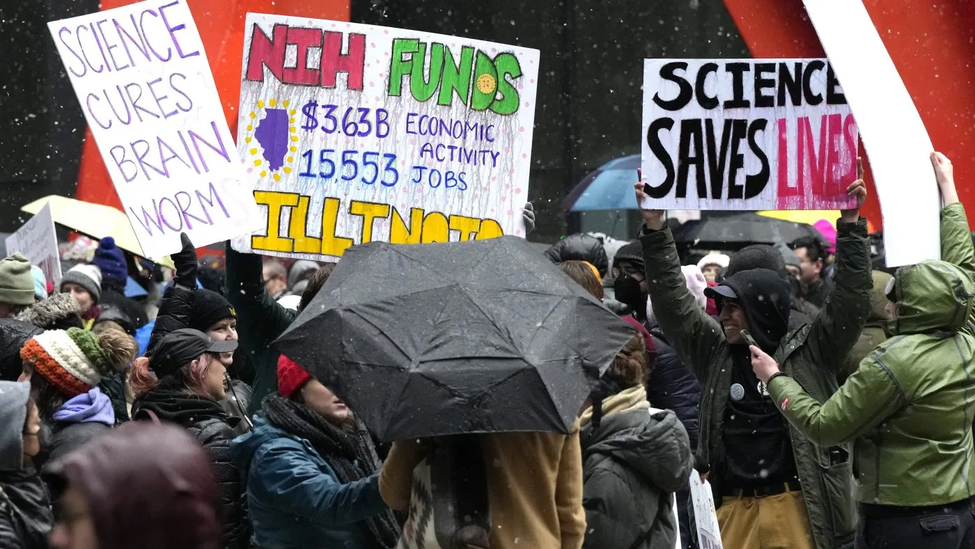 People hold signs as they stand up for Science rally to protest the Trump administration’s science policies and federal job cuts Friday, March 7, 2025, in Chicago. (AP Photo/Nam Y. Huh)