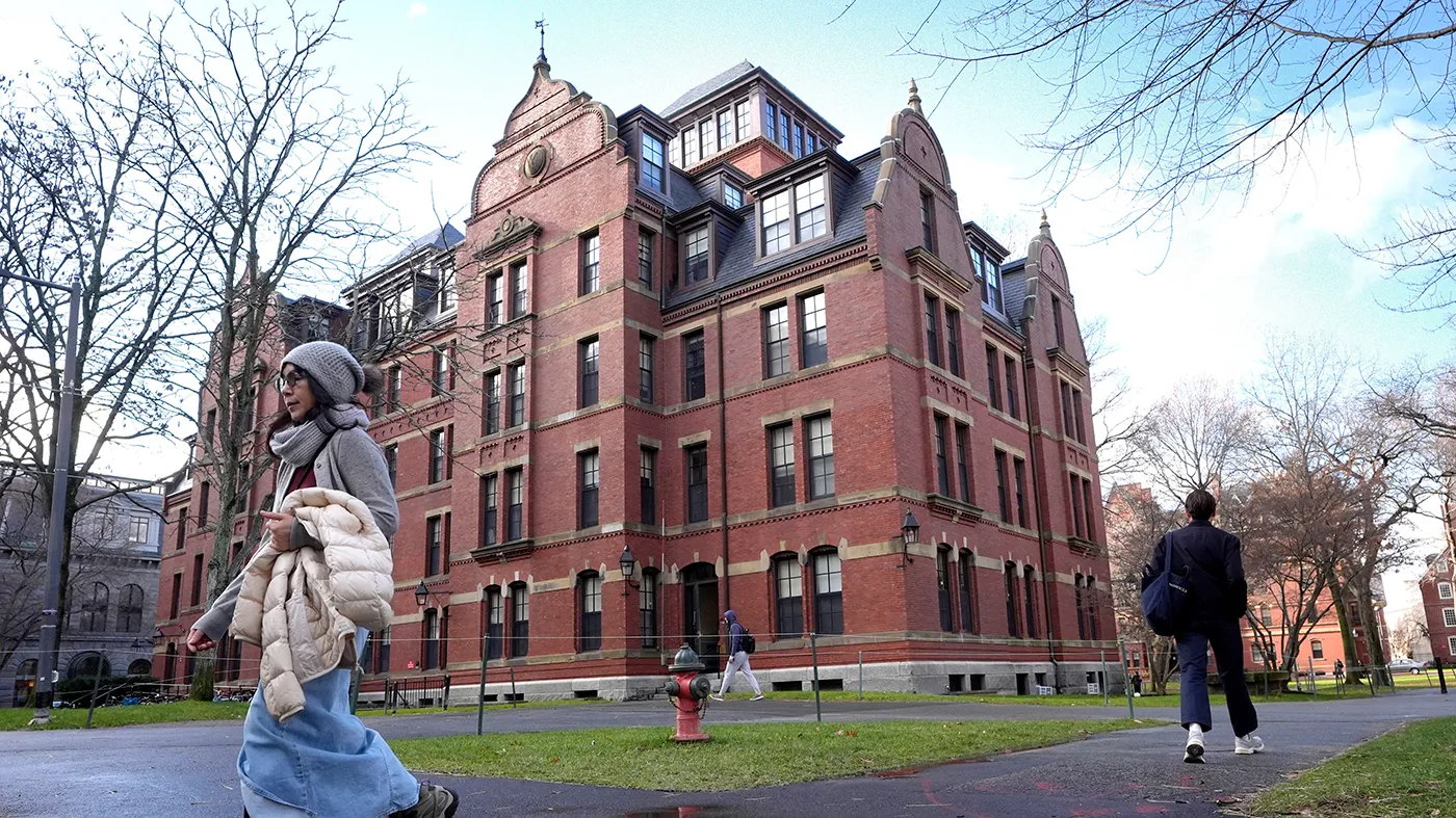 People walk between buildings, Dec. 17, 2024, on the campus of Harvard University in Cambridge, Mass.