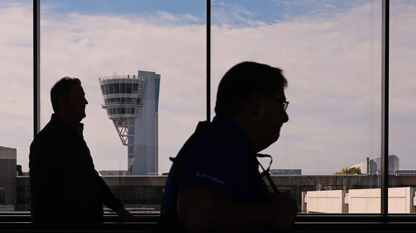 Travelers move in view of a control tower at Philadelphia International Airport in Philadelphia, Wednesday, Nov. 5, 2025. (AP Photo/Matt Rourke)