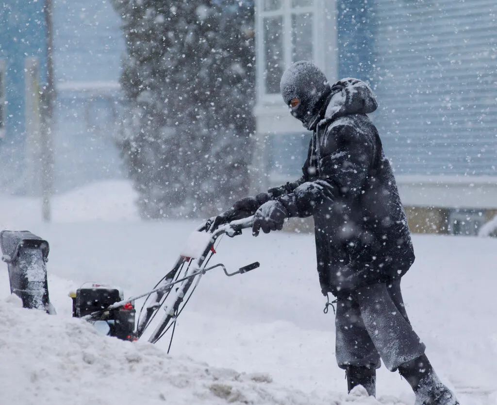 A man uses a snow blower in West Bend, Wisconsin Feb. 1, 2011. (AP Photo/Jeffrey Phelps)