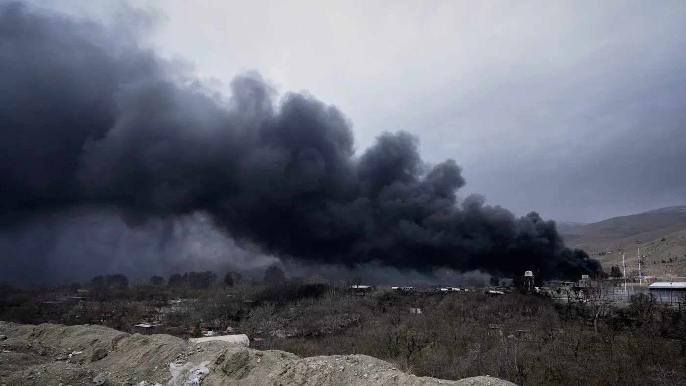 A thick plume of smoke rises from an oil storage facility hit by a U.S.-Israeli strike late Saturday in Tehran, Iran, March 8, 2026.