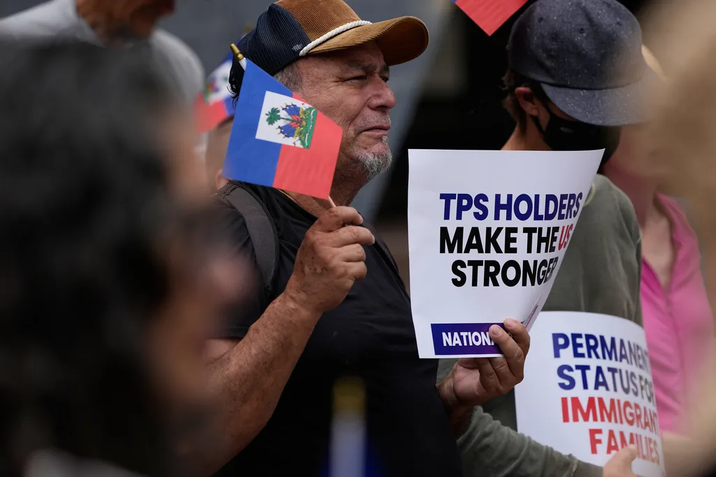 People hold Haitian flags and signs during a rally in support of immigrants living in the United States with temporary protected status, or TPS, Thursday, July 9, 2026, in San Diego. (AP Photo/Gregory Bull)