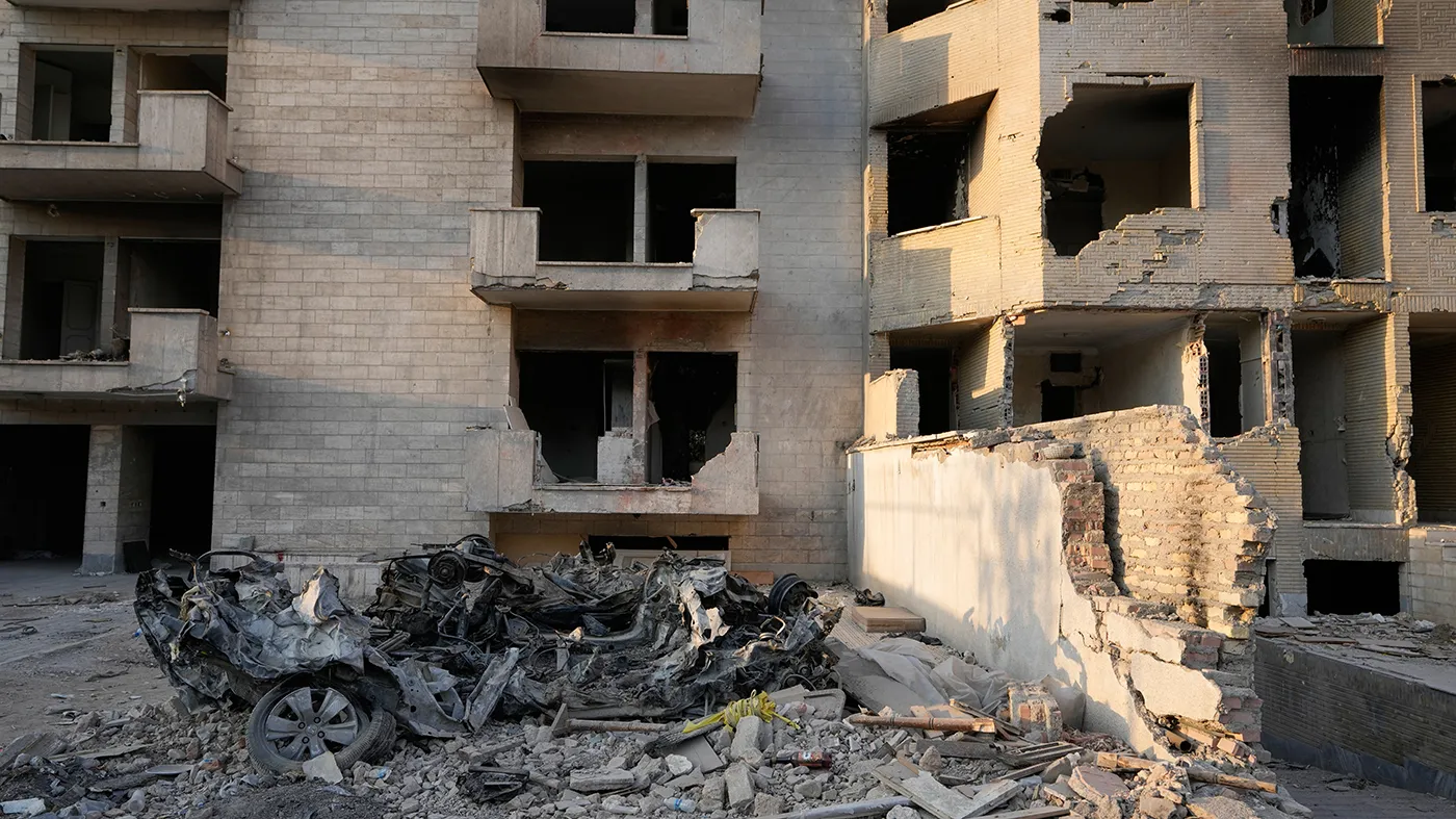 Cars and residential buildings damaged in a U.S.-Israeli strike on March 8 remain in ruins in Tehran, Iran, Thursday, Aug. 27, 2026.