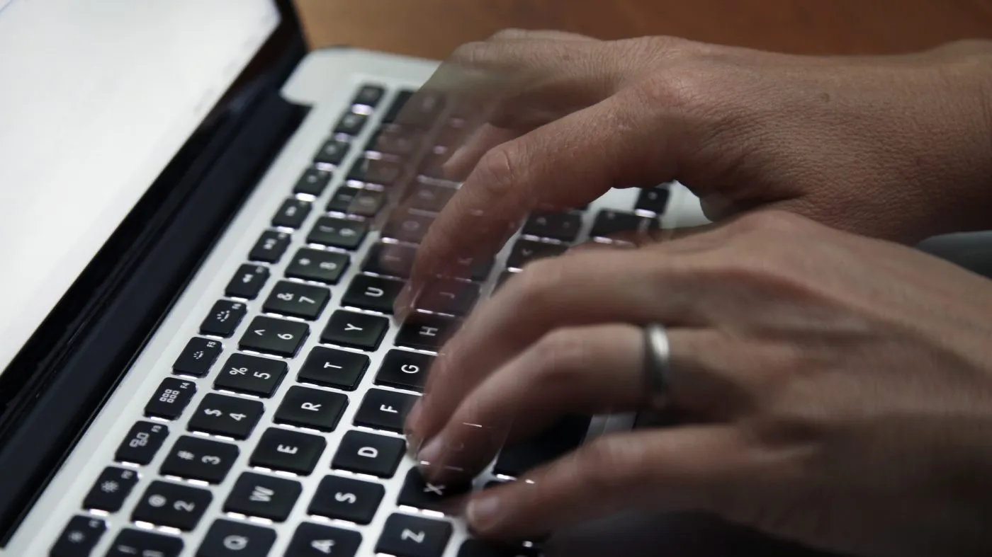 FILE – Person working on a laptop in North Andover, Mass. (AP Photo/Elise Amendola, File)