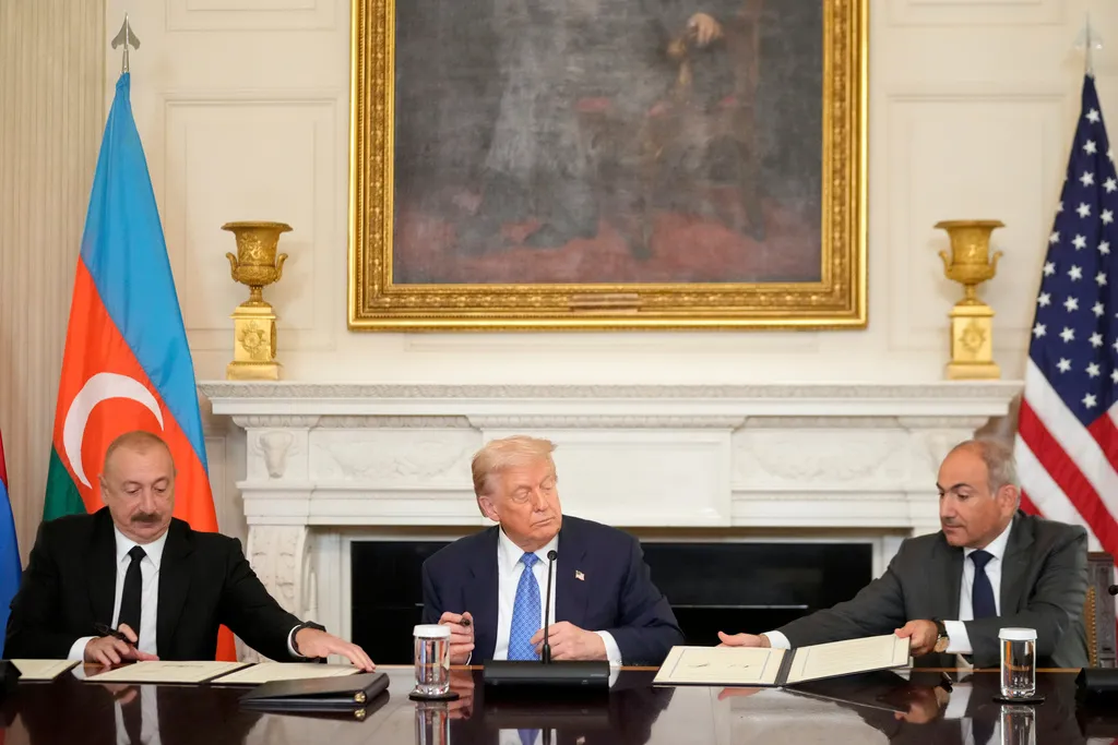President Donald Trump, center, Armenian Prime Minister Nikol Pashinyan, right, and Azerbaijan President Ilham Aliyev sign a trilateral agreement during a ceremony in the State Dining Room of the White House, Friday, Aug. 8, 2025, in Washington. (AP Photo/Mark Schiefelbein)