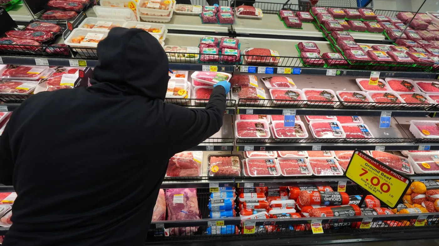 A grocery store worker places ground beef in the meat display in Dallas, Wednesday, April 15, 2026. (AP Photo/LM Otero)