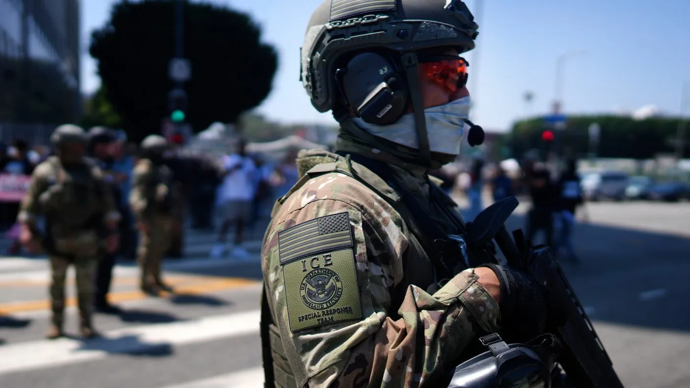An ICE Special Response Team member stands guard outside the Metropolitan Detention Center, while protesters gather outside to denounce U.S. Immigration and Customs Enforcement operations, June 10, 2025, in downtown Los Angeles.