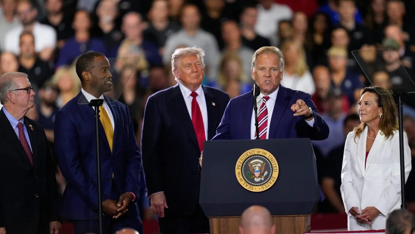 Republican Senate candidate Mike Rogers speaks as Rep. Tim Walberg (R-Mich.), Rep. John James (R-Mich.), President Trump and Rep. Lisa McClain (R-Mich.) listen at an event at the General Motors Proving Ground on July 27, 2026, in Milford, Mich.