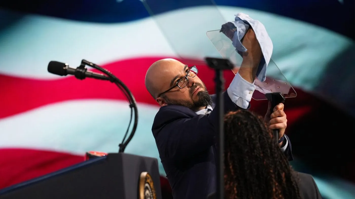 FILE – Gabriel Perez cleans the teleprompter before President Donald Trump speaks at the Future Investment Initiative Institute’s summit, March 27, 2026, in Miami Beach, Fla. (AP Photo/Mark Schiefelbein, File)