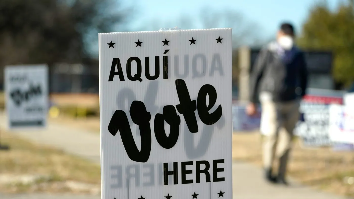 A man passes an early voting poll site, Feb. 14, 2022, in San Antonio.