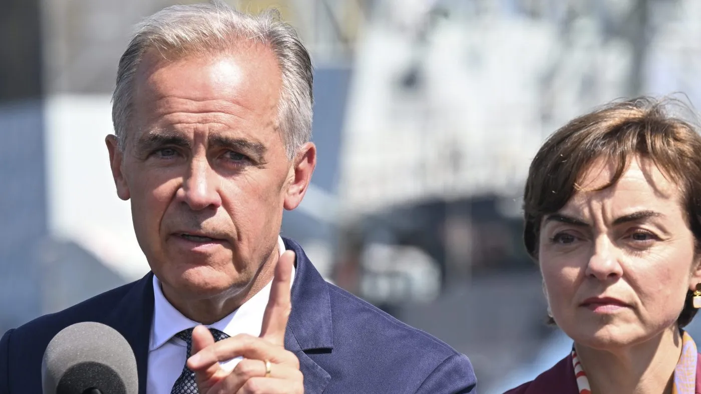 Canadian Prime Minister Mark Carney speaks as he announces a $11.3 billion contract for icebreakers at the Davie shipyard in Levis, Quebec, Aug. 24, 2026. Quebec Premier Christine Fréchette, right, looks on.