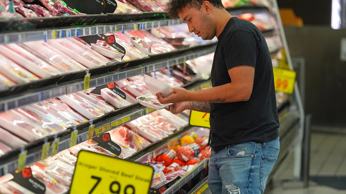 A shopper looks at packages of meat at a grocery store in Dallas, April 15, 2026.