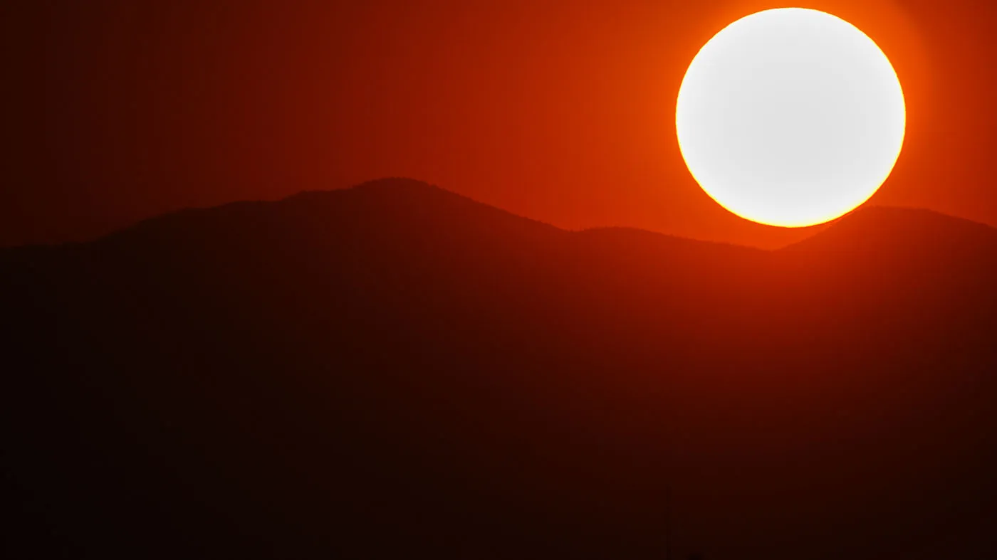 The setting sun colors the sky behind the Rocky Mountains, Aug. 6, 2026, in Denver.