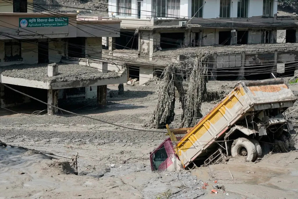 Damaged houses and vehicles are seen in the aftermath of flash floods along the Trishuli River in Nepal’s Nuwakot district, Wednesday, Aug. 26, 2026. (AP Photo/Niranjan Shrestha)