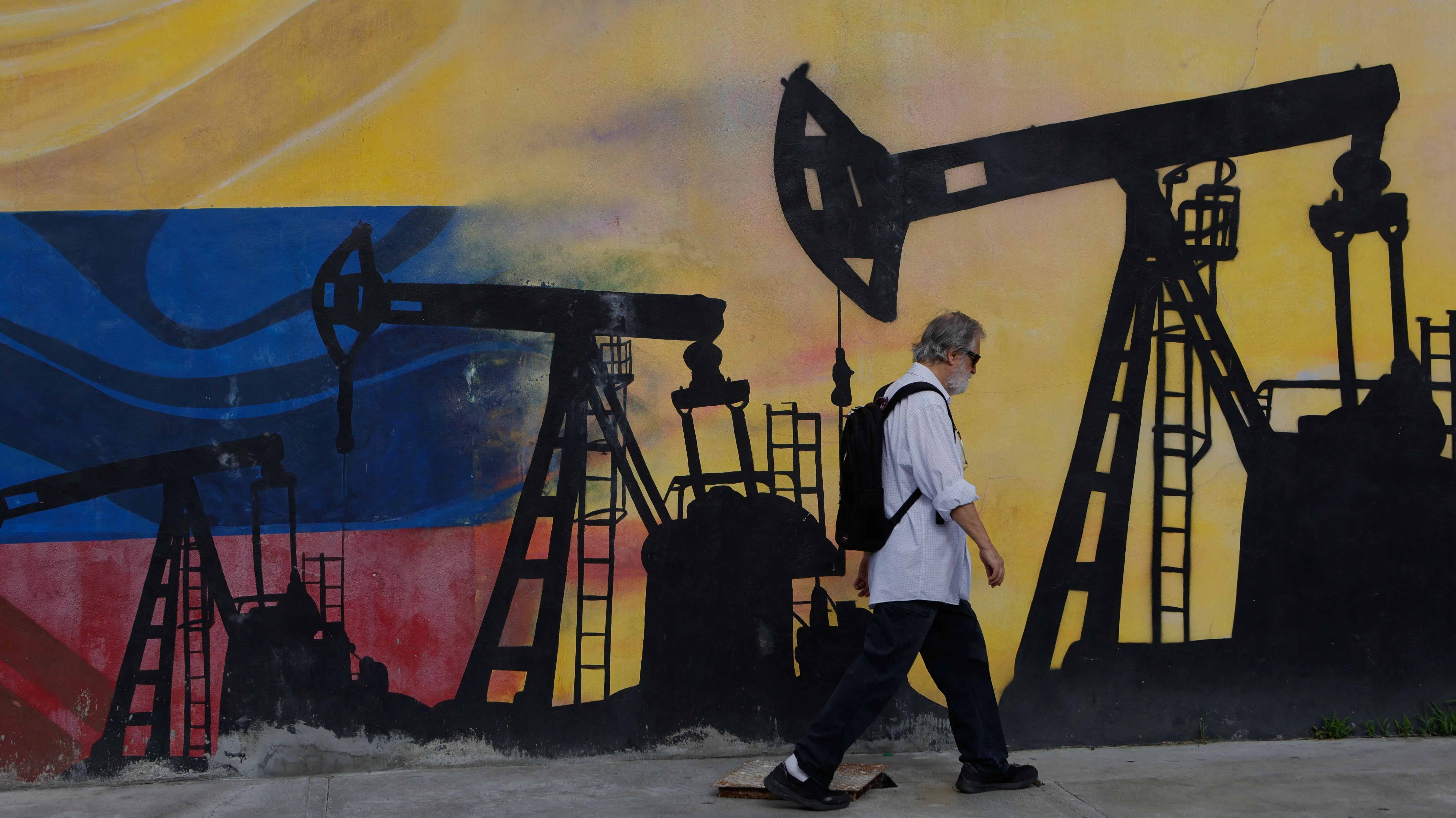 A pedestrian walks past a mural featuring oil wells in Caracas, Venezuela, on Aug 29, 2026. President Trump announced a deal giving the United States a stake in Venezuela’s oil reserves the day before.