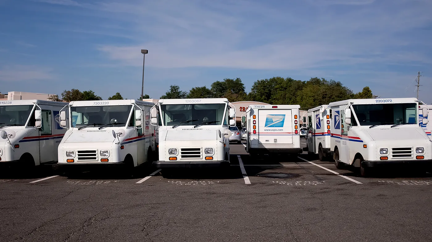 U.S. Postal Service trucks are seen in a parking lot at the Newgate Shopping Center in Centerville, Va., on Oct. 14, 2021.
