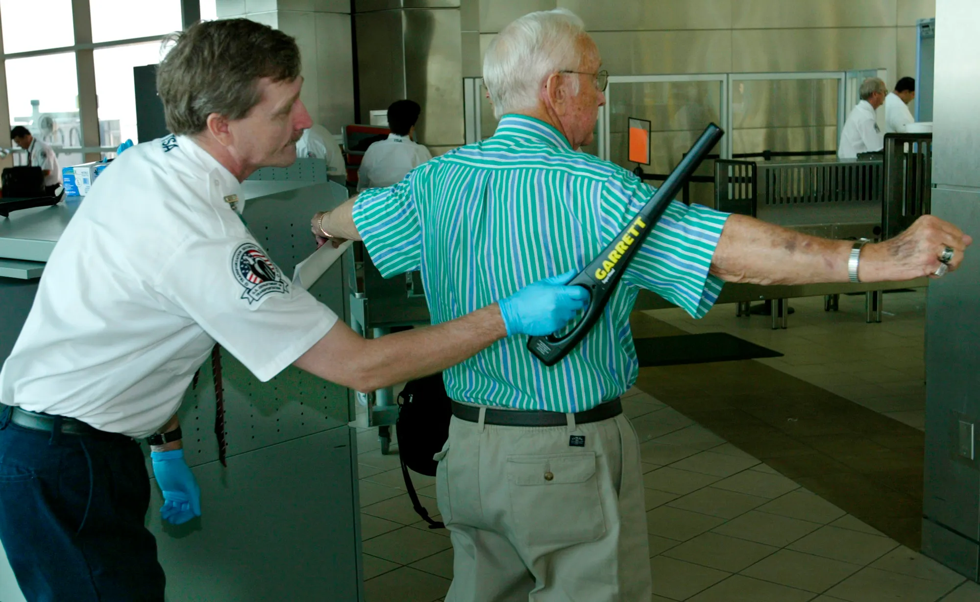 ** ADVANCE FOR THURSDAY, SEPT. 11 **Transportation Security Administration agent Terry Brassfield, left, checks a passenger at a security checkpoint at Will Rogers World Airport in Oklahoma City, Tuesday, Sept. 9, 2003. Airport security increased around the country following the Sept. 11 terror attacks. (AP Photo/Sue Ogrocki)