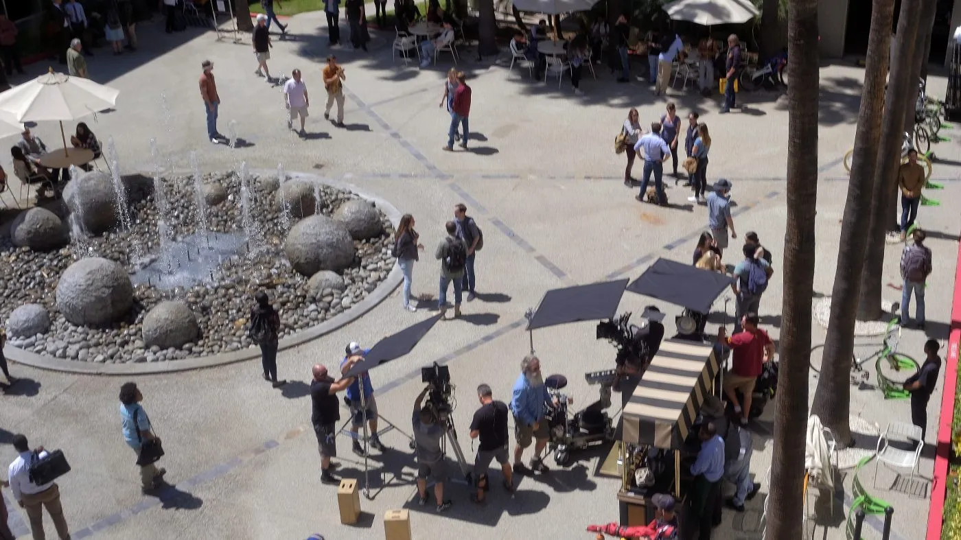 Production crew, extras and camera operators get ready to film an episode of “NCIS: Los Angeles” on location in Los Angeles on May 1, 2017.
