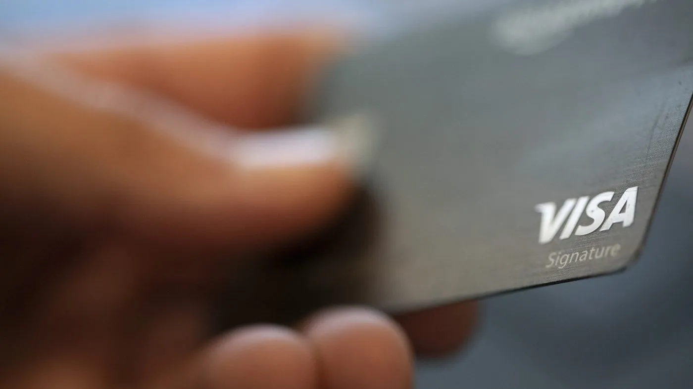 FILE – This Aug. 11, 2019, file photo shows a Visa logo on a credit card in New Orleans. Credit union credit cards are sometimes overlooked when ads for bank-issued credit cards and their many perks steal focus. But you may be missing out if you don’t consider these cards as potential candidates for your wallet. Sometimes credit union credit cards have rich offers or provide value in the form of lower fees and interest rates. (AP Photo/Jenny Kane, File)