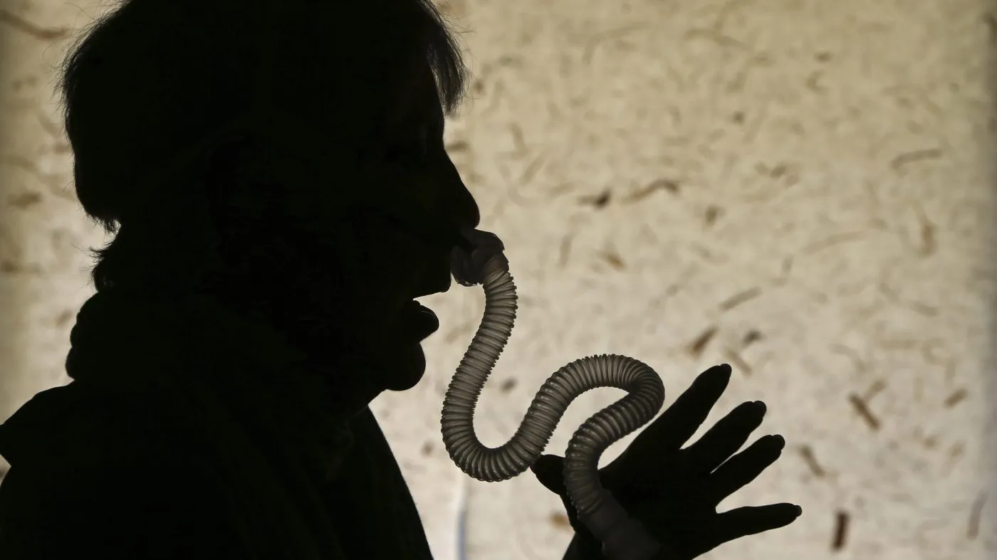 FILE – A woman demonstrates how she puts on her sleep apnea breathing device at her home in Los Angeles Thursday, July 12, 2018. Tirzepatide, used to treat diabetes and obesity, can help with sleep apnea, a dangerous disorder in which people struggle to breathe while they sleep, according to a study, published Friday, June 21, 2024, in the New England Journal of Medicine, (AP Photo/Reed Saxon, File)