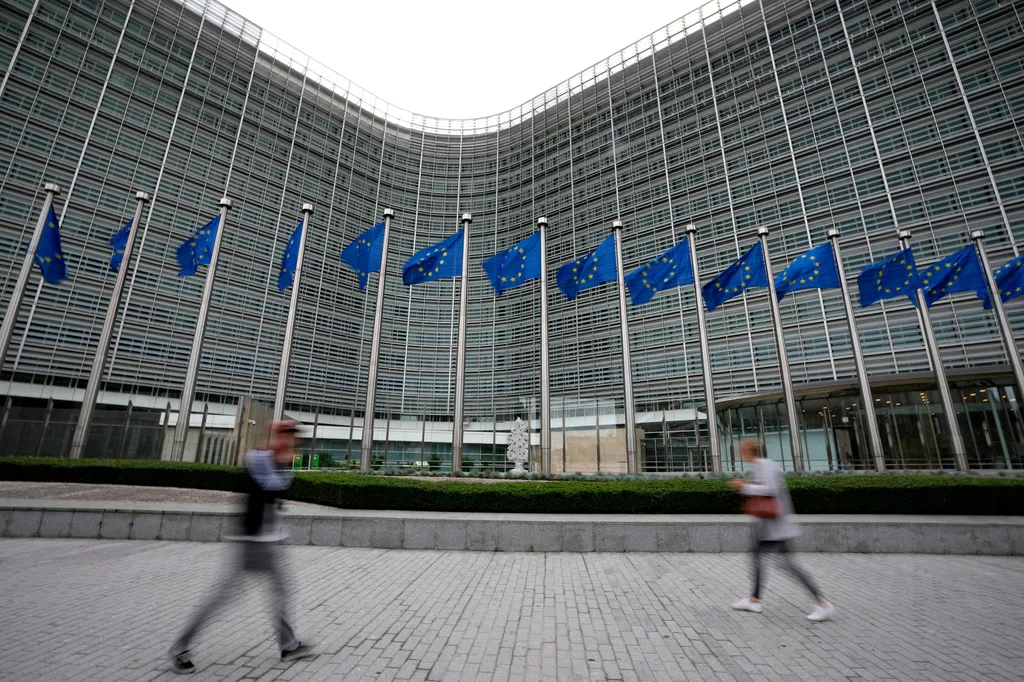 FILE – European Union flags flap in the wind as pedestrians walk by EU headquarters in Brussels, Wednesday, Sept. 20, 2023. (AP Photo/Virginia Mayo, File)