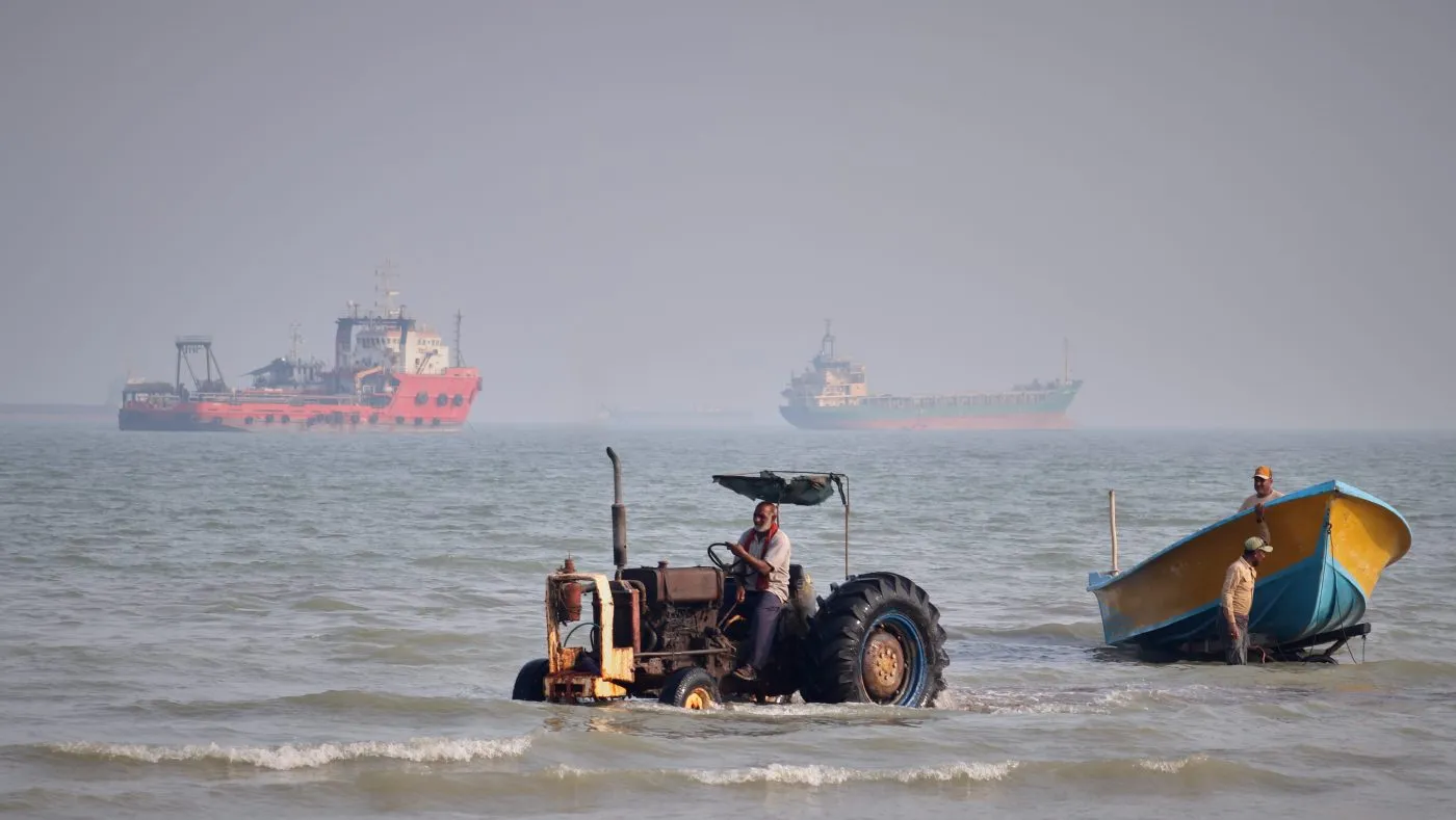 A tractor pulls a boat from the sea as commercial vessels are anchored in the Strait of Hormuz off Bandar Abbas, Iran, on Aug. 31, 2026.