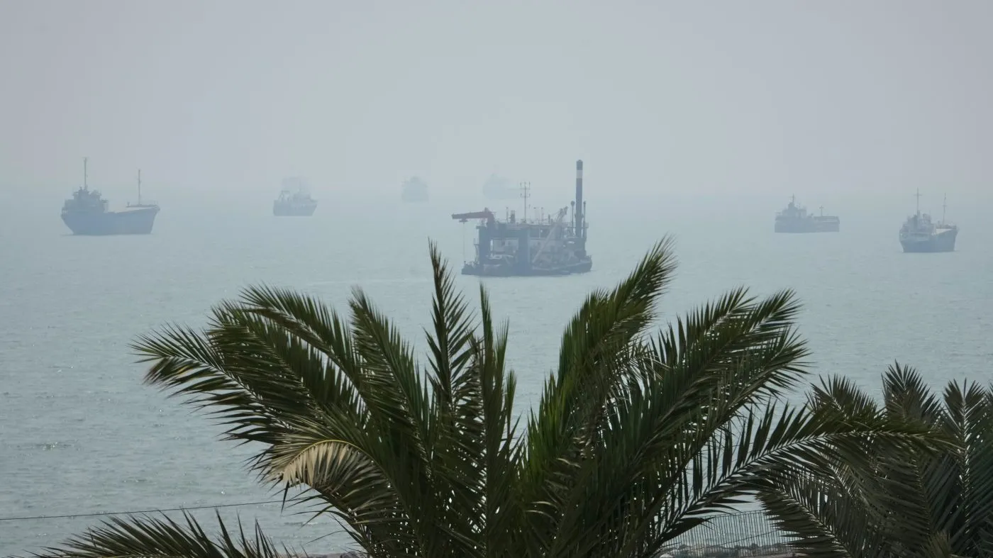 A floating dredging platform and commercial vessels lie anchored amid haze in the Strait of Hormuz off Bandar Abbas, Iran, Monday, Sept. 7, 2026. (AP Photo/Vahid Salemi)