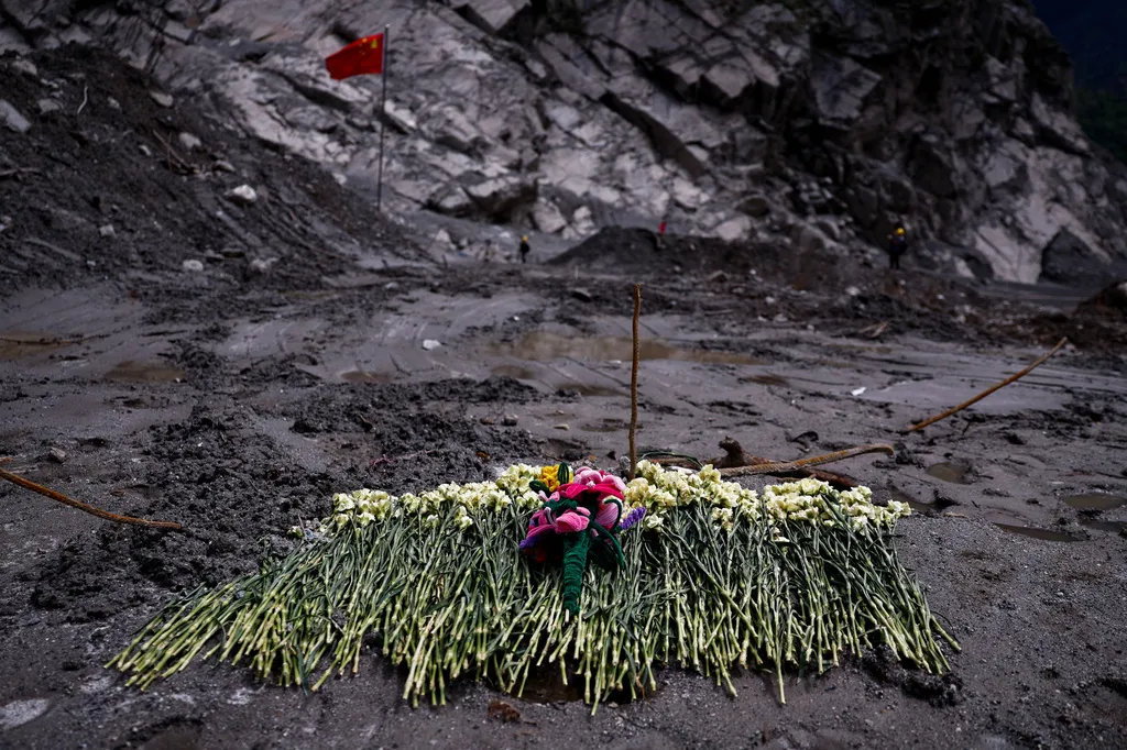 Flowers are placed on mud as tribute at a disaster-hit area at Gyirong Port amid rescue efforts following the Aug. 26 mudslide during a media tour in Shigatse, Tibet autonomous region, China, Sunday, Sept. 6, 2026. (Tingshu Wang/Pool Photo via AP)
