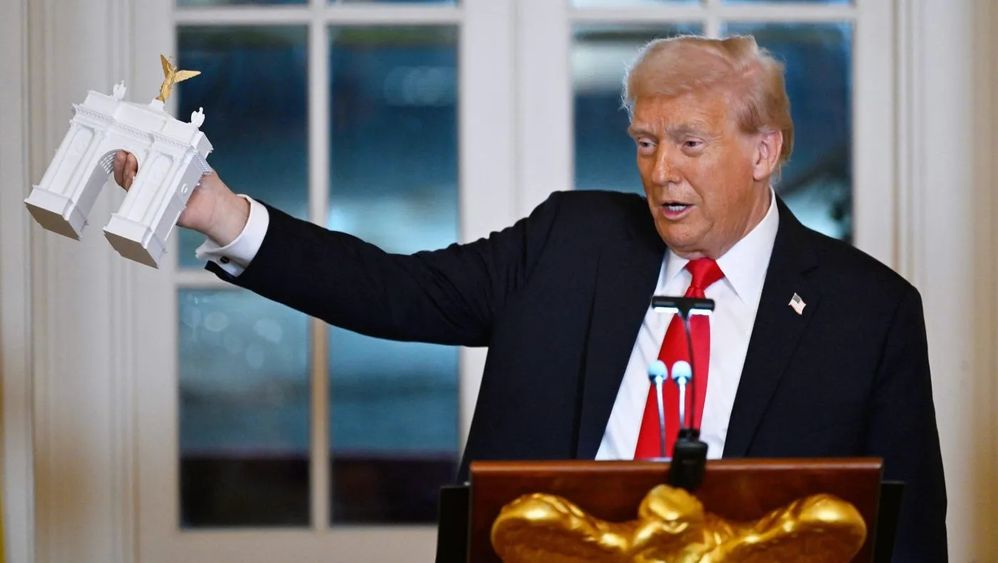 FILE – President Donald Trump holds up a model of the proposed triumphal arch as he addresses a dinner for donors who have contributed to build the new ballroom at the White House, Oct. 15, 2025, in Washington. (AP Photo/John McDonnell, File)