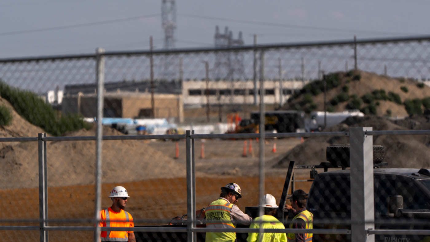 Workers talk outside an Amazon Web Services data center that is under construction on Wednesday, Aug. 21, 2024, in Boardman, Ore. (AP Photo/Jenny Kane)
