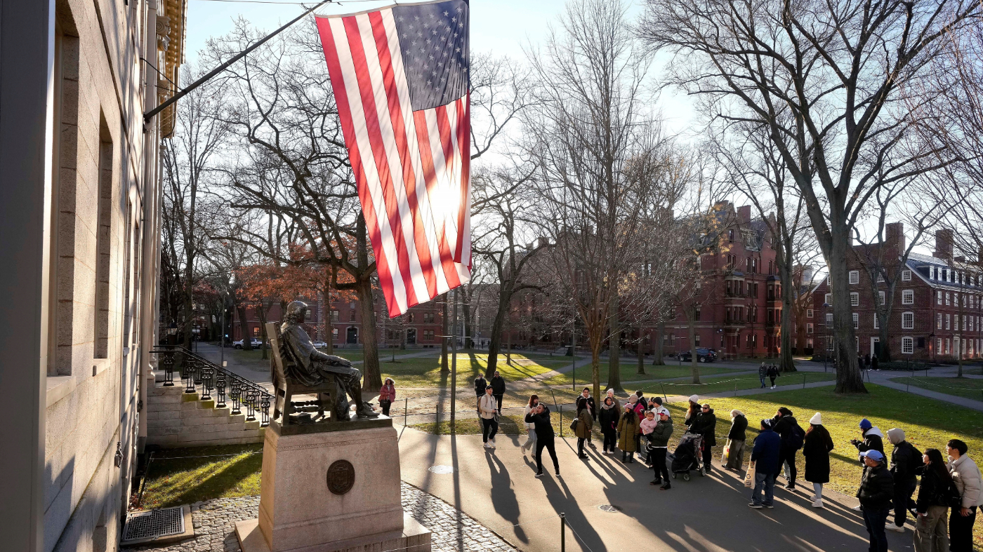 FILE – People take photos near a John Harvard statue, left, on the Harvard University campus, Jan. 2, 2024, in Cambridge, Mass. (AP Photo/Steven Senne, File)