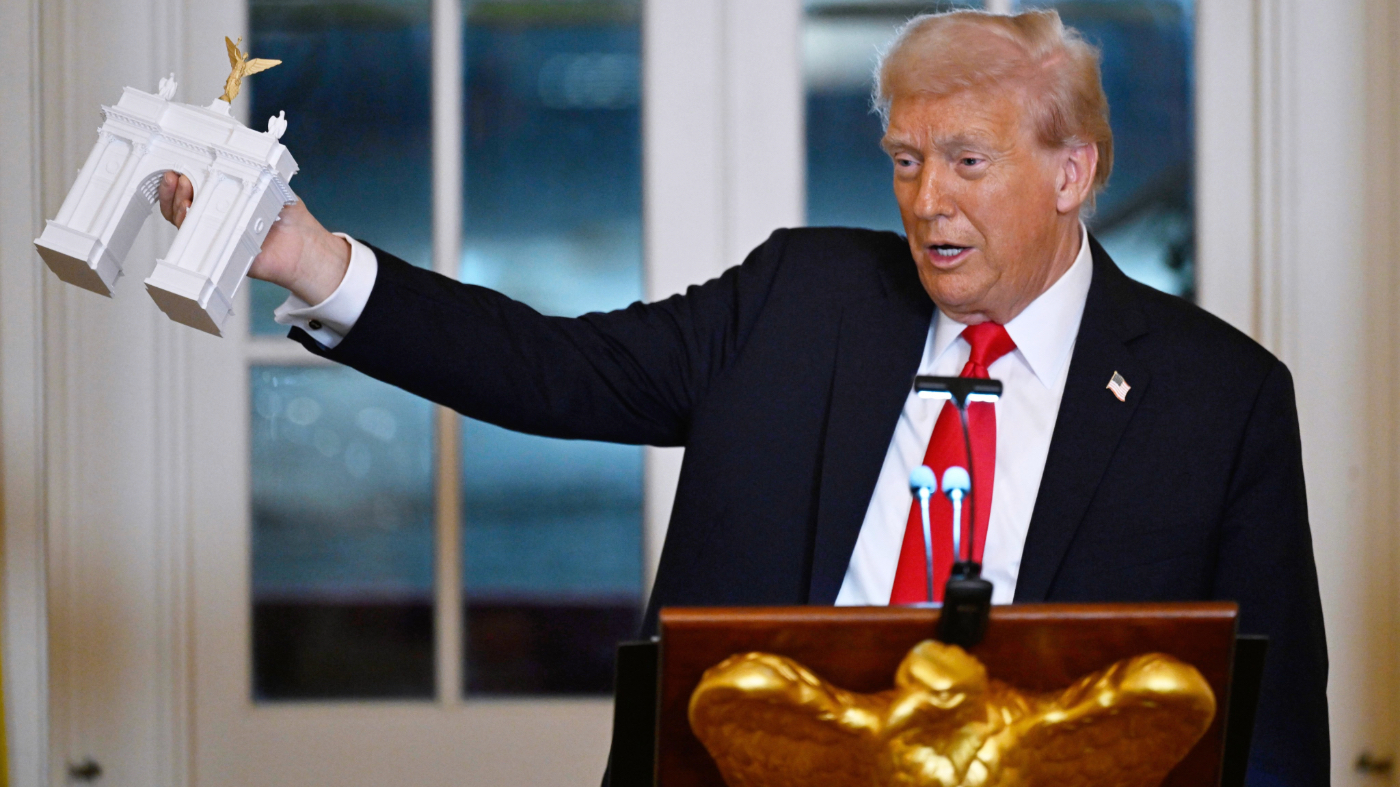 FILE – President Donald Trump holds up a model of the proposed triumphal arch as he addresses a dinner for donors who have contributed to build the new ballroom at the White House, Oct. 15, 2025, in Washington. (AP Photo/John McDonnell, File)