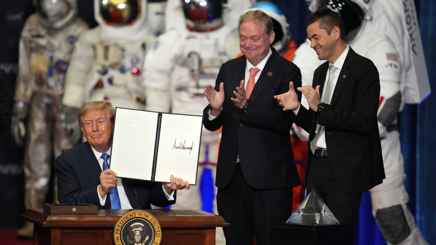 President Donald Trump holds up an order to create the U.S. Space Academy before a Congressional Space Medal of Honor ceremony at NASA’s Johnson Space Center, Friday, Aug. 28, 2026, in Houston, as Kevin Hassett, director of the National Economic Council and NASA Administrator Jared Isaacman, right, look on. (AP Photo/Karen Warren)