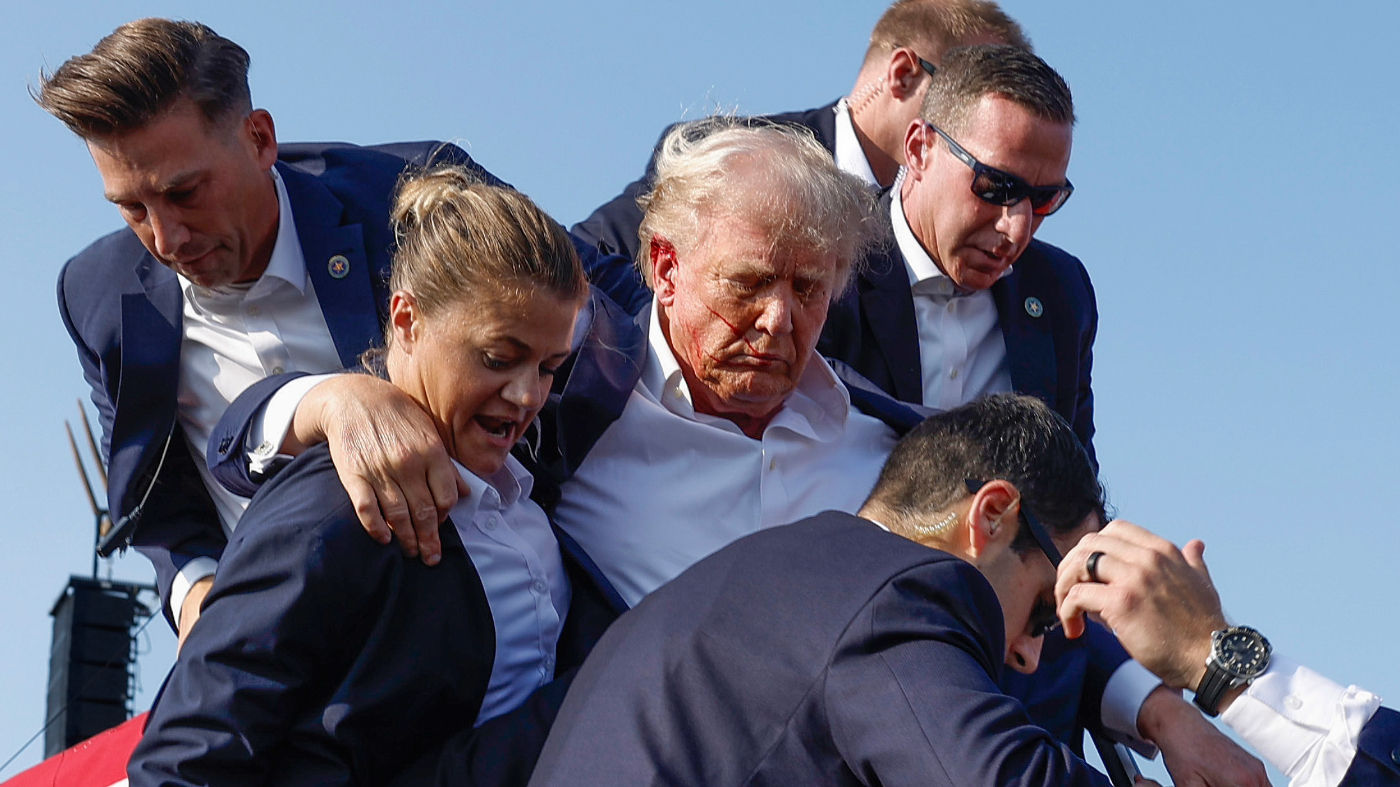 Republican presidential candidate former President Donald Trump is rushed offstage by U.S. Secret Service agents after being grazed by a bullet during a rally on July 13, 2024 in Butler, Pennsylvania. (Photo by Anna Moneymaker/Getty Images)