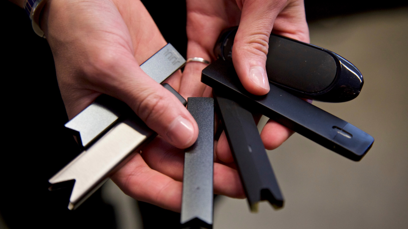 FILE – In this April 16, 2019 file photo, a researcher holds vape pens in a laboratory in Portland, Ore. (AP Photo/Craig Mitchelldyer, File)