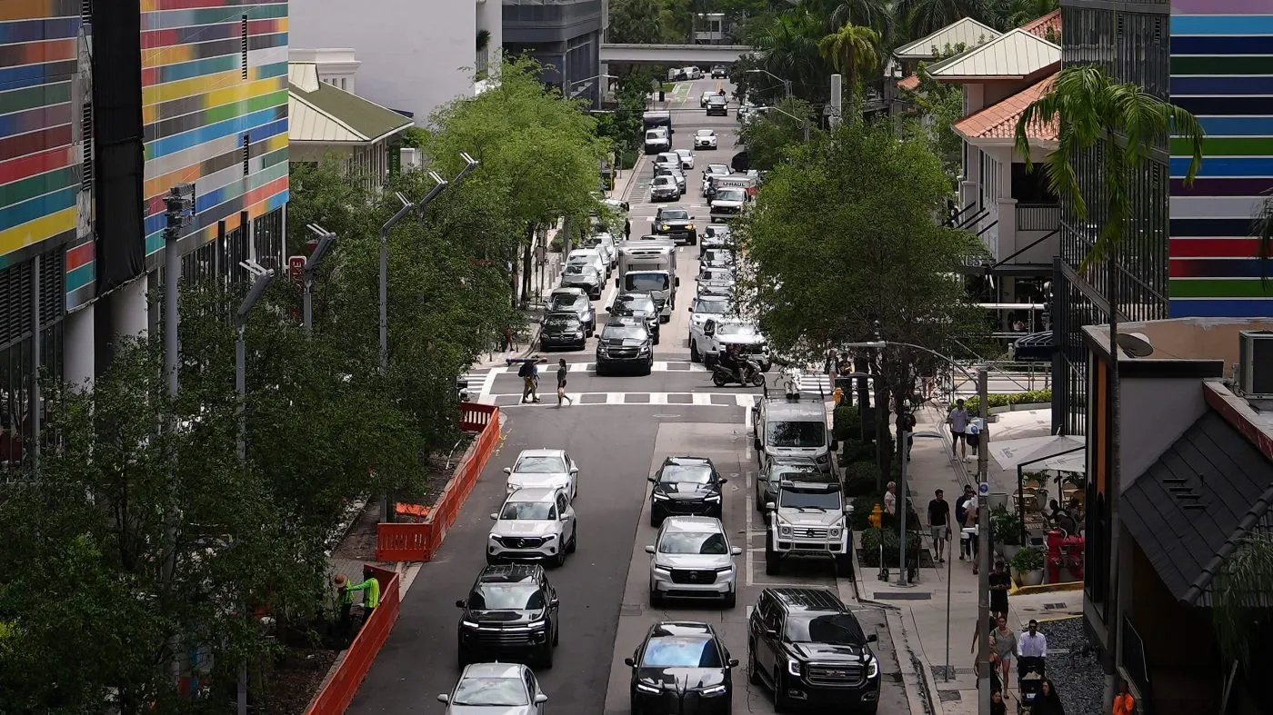 Cars drive through a commercial area, Thursday, April 2, 2026, in the Brickell neighborhood of Miami. (AP Photo/Rebecca Blackwell)