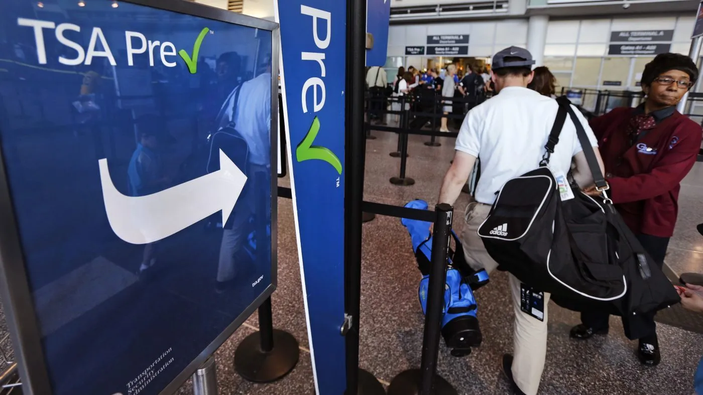 FILE – A passenger passes by a sign for the Transportation Security Administration’s TSA PreCheck line in Terminal A at Logan Airport in Boston, Monday, June 27, 2016. (AP Photo/Charles Krupa, File)