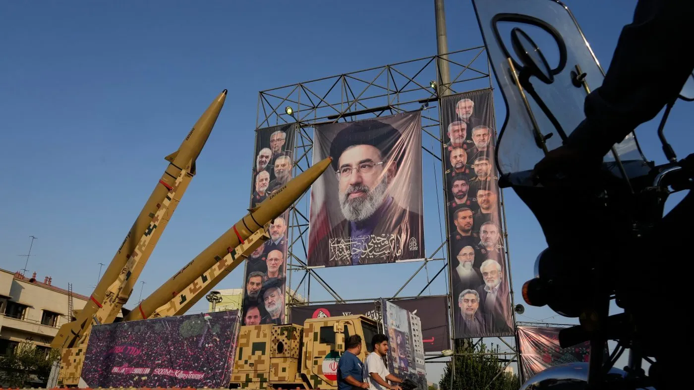 Motorbikes drive past Iranian missiles and banners showing portraits of the Iranian Supreme Leader Ayatollah Mojtaba Khamenei, center, and the late armed forces commanders and nuclear scientists, who were killed in Israeli and U.S. strikes, displayed in a military exhibition commemorating the anniversary of the start of the 1980-88 Iraq-Iran war at Baharestan Square, in Tehran, Monday, Sept. 28, 2026. (AP Photo/Vahid Salemi)