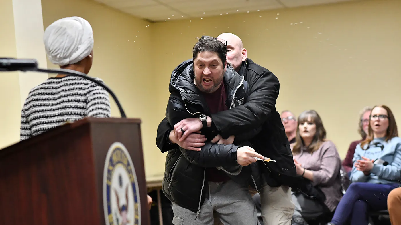 A man is tackled after spraying an unknown substance at Rep. Ilhan Omar (D-Minn.) during a town hall she was hosting in Minneapolis, Minn., on Jan. 27, 2026.