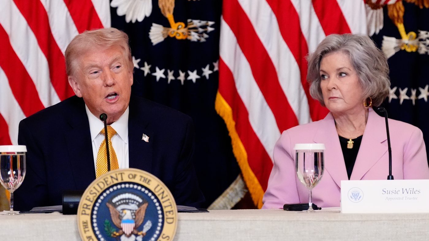President Trump speaks during a board meeting of the John F. Kennedy Memorial Center For The Performing Arts in the East Room of the White House, March 16, 2026, in Washington, as White House Chief of Staff Susie Wiles, looks on.